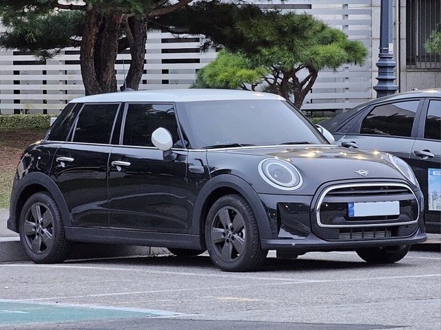 Mini Cooper 5 portas preto visto de frente em três quartos