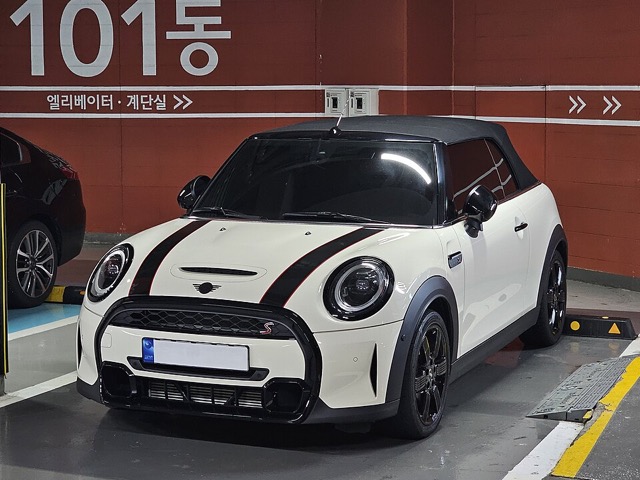 Mini Cooper Cabrio branco visto de frente em três quartos
